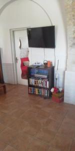 Zimmer mit einem Bücherregal und einem Flachbild-TV in der Unterkunft La Casolare in Condoianni