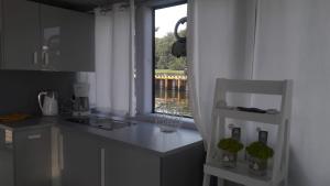 une cuisine avec un comptoir blanc et une fenêtre dans l'établissement Sunrise Houseboat, à Świnoujście