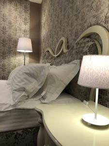 ヴィーンヌィツャにあるHotel Boutique TOVMEDのベッドルーム(枕、ランプ付)