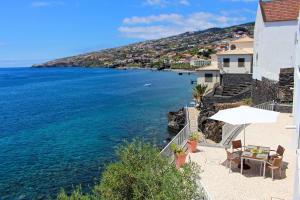 a beach with chairs and an umbrella and the water at The Artist Villa in Santa Cruz