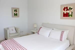 a white bedroom with a bed and a chair at The Artist Villa in Santa Cruz +30 photos
