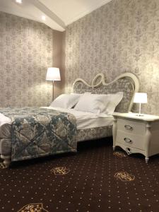 a bedroom with a bed and a table with a nightstand at Hotel Boutique TOVMED in Vinnytsya +78 photos
