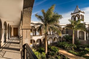 a building with palm trees and a clock tower at Royal Palm Resort & Spa - Adults Only in Playa Jandia