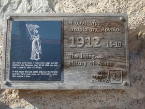 a sign on the side of a stone wall at Oikia Alexandrou Traditional Inn in Arnaia