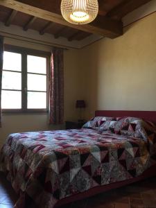 a bedroom with a bed with a quilt on it at Podere dell'Alloro in Palaia