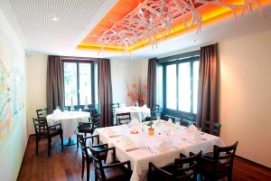 a dining room with white tables and chairs at Gasthaus zur Waldegg in Luzern