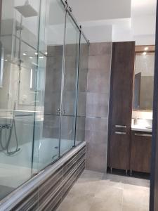 een glazen douche in een badkamer met een wastafel bij Angela's Sea View 3 BD House in Kato Daratso