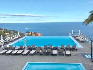 a swimming pool with chairs and the ocean in the background at COSTA PLANA COLLECTION - Cap d'Ail - Monaco in Cap d'Ail