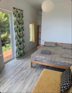 a bedroom with a bed and a large window at Guest House Lesnaya Koshka in Simeiz