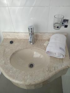 Hotel Boggiani في أسونسيون: مغسلة الحمام عليها منشفة بيضاء