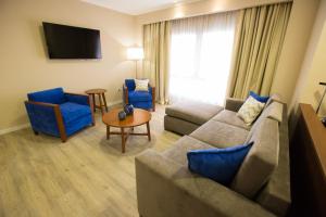 uma sala de estar com um sofá e duas cadeiras azuis em PLATINUM HOTEL CASINO em Charata