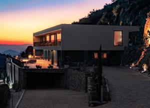 una casa al lado de una montaña al atardecer en Encostas da Baronesa, en Alijó