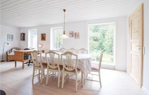 un comedor blanco con mesa y sillas en Nice Home In Randbl With Kitchen en Randbøl