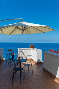 a patio with tables and chairs and an umbrella at B&B La Terrazza in Cetraro