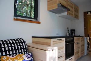 a kitchen with wooden cabinets and a stove top oven at Tiny House Ruheoase in Zwettl Stadt