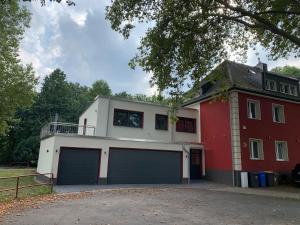 a red and white house with two garage doors at Sonnige Apartments mit Terrasse in Essen