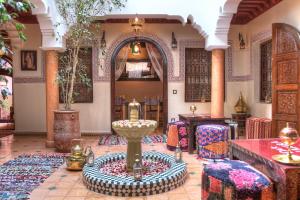 a room with a fountain in the middle of a building at Dar Al Hamra in Marrakech