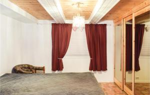 a bedroom with a bed and red curtains at 3 Bedroom Gorgeous Apartment In Giske in Gjuv