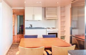 cocina con mesa de madera y sillas azules en 3 Bedroom Gorgeous Apartment In Giske, en Gjuv