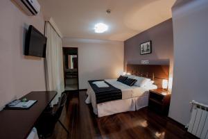 Pokój hotelowy z łóżkiem i biurkiem w obiekcie Santa Catarina Plaza Hotel w mieście Canoinhas
