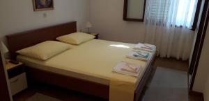 a bedroom with a bed with two towels on it at Apartment Perović in Baška Voda