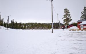 a snow covered parking lot with benches and a building at Nice Home In Gol With Kitchen in Gol