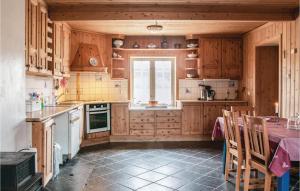 une cuisine avec des placards en bois, une table et une fenêtre dans l'établissement Beautiful Home In Tynset With Kitchen, à Tynset