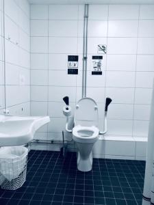 a bathroom with a toilet and a tub and a sink at Golden Hostel in Järfälla