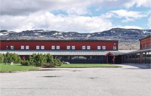 a large red building with mountains in the background at Stunning Apartment In Hovden I Setesdal With House A Mountain View in Hovden