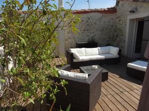 un patio avec un canapé et des chaises sur une terrasse dans l'établissement La Fleury, à Arles