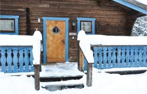 a wooden house with a blue door in the snow at Nice Home In Lima With 1 Bedrooms And Wifi in Lima