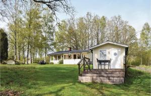 een klein huis in een tuin met een veranda bij Cozy Home In Ljungby With Kitchen in Ljungby