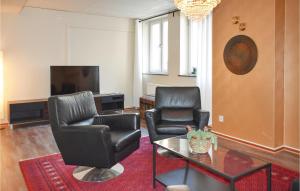 een woonkamer met 2 stoelen, een tafel en een tv bij Awesome Apartment In Karlskrona With Wifi in Karlskrona