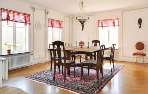 a dining room with a table and chairs on a rug at 4 Bedroom Gorgeous Home In Lindesberg in Lindesberg