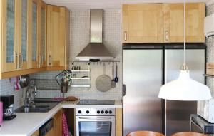 a kitchen with wooden cabinets and a stainless steel refrigerator at Gorgeous Apartment In Holmsund With Sauna in Holmsund
