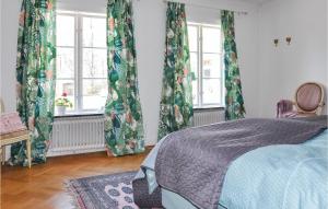 4 Bedroom Gorgeous Home In Lindesberg في لينديسبرغ: غرفة نوم مع ستائر خضراء وسرير مع سجادة