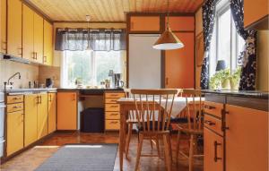 cocina con armarios amarillos, mesa y sillas en Amazing Home In Torup With 2 Bedrooms And Wifi, en Torup