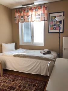 a bedroom with a white bed with a window at Golden Hostel in Järfälla