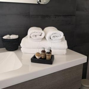 a bathroom counter with towels and jars of honey at La Clé du Puy in Cabariot