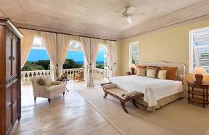 um quarto com uma cama e uma varanda com o oceano em Royal Westmoreland Benjoli Breeze, Palm Ridge 10 by Island Villas em Saint James