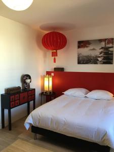 1 dormitorio con cabecero rojo y cama blanca en Le Fuji centre la Brèche wifi calme vue jardin, en Niort