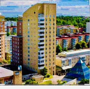 a tall building in the middle of a city at Golden Hostel in Järfälla