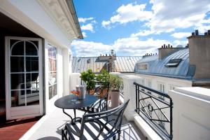 - un balcon avec une table et des chaises dans l'établissement L'Hôtel, à Paris