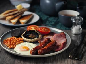 a plate of breakfast food with eggs bacon beans and toast at Absoluxe Suites in Kirkby Lonsdale