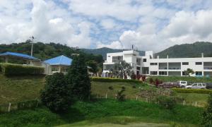 a white building on a hill in front of a building at Terrazas De Baltimoores in San Joaquín