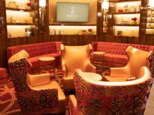 a waiting room with a red couch and chairs at SAHARA Las Vegas in Las Vegas