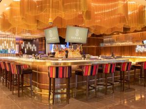a bar in a hotel with bar stools at SAHARA Las Vegas in Las Vegas