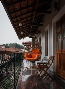 帕納吉的住宿－O Abrigo，阳台的门廊配有秋千和椅子