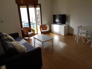 a living room with a couch and a table and a tv at Apartamento en Figueras, Asturias in Castropol