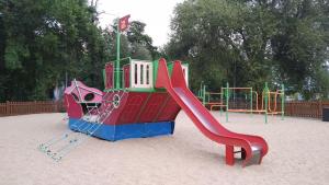 a playground with a slide in the sand at Studio Red Kot in Zielona Góra
